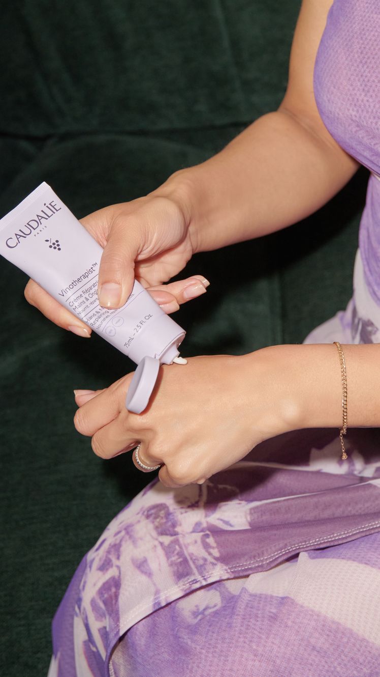 Caudalie Hand Nail Cream being applied to hand of Shanna Shipin purple packaging