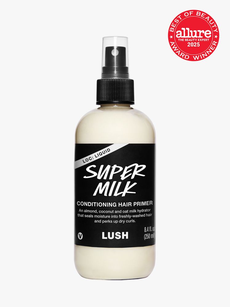 Lush Super Milk Conditioning Hair Primer in branded clear bottle with black spray pump on light gray background with red...