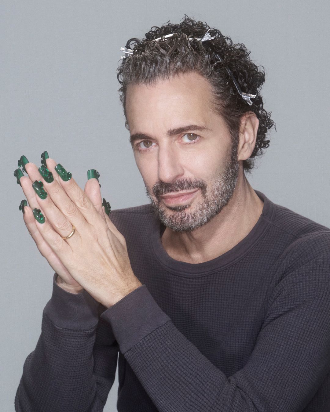 Marc Jacobs posing in a dark longsleeve shirt and long green nails