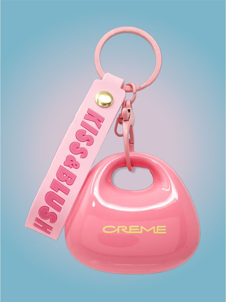 The Crème Shop Kiss  Blush Lip  Cheek Balm in branded component on a pink and blue background