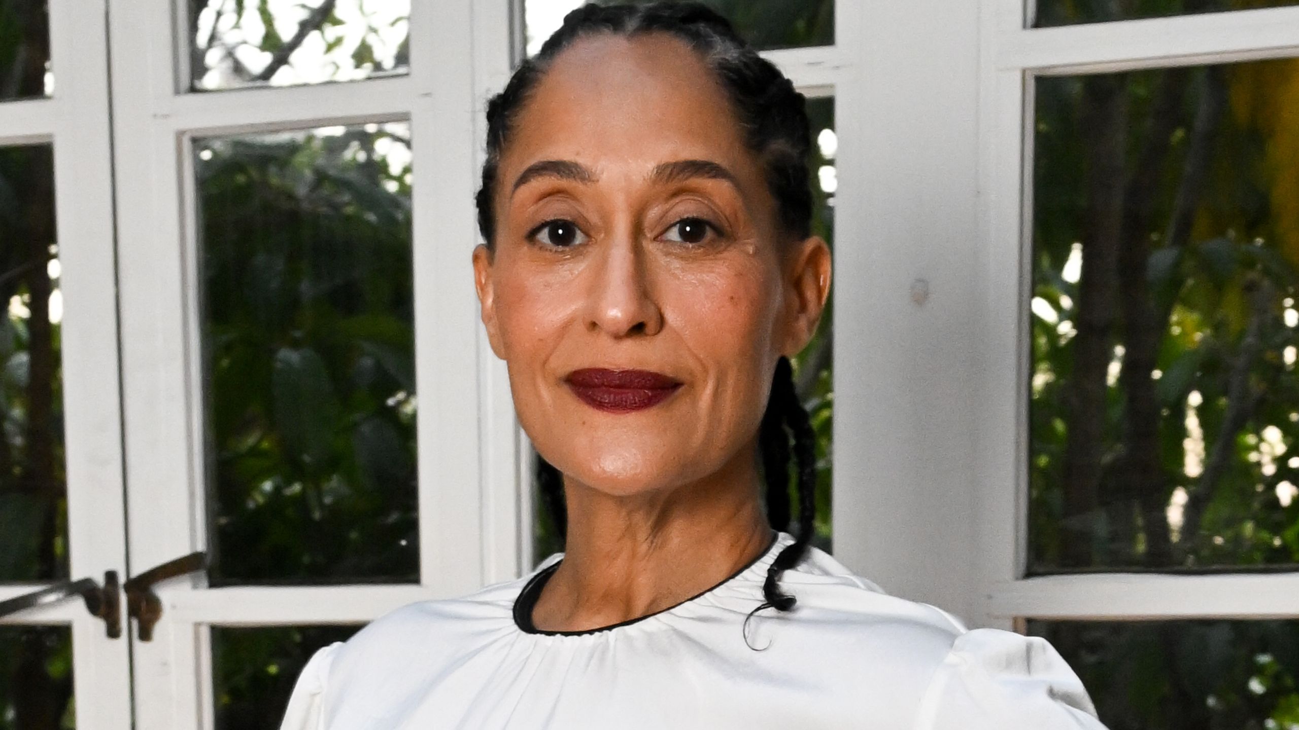 Tracee Ellis Ross wears an allwhite outfit and dark lipstick.