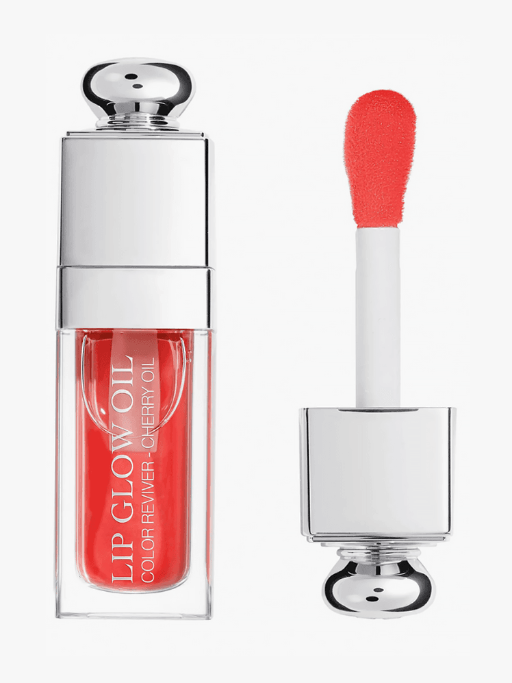 Lip Glow Oil in Poppy Coral in branded clear glass tube with silver doe foot applicator on light gray background